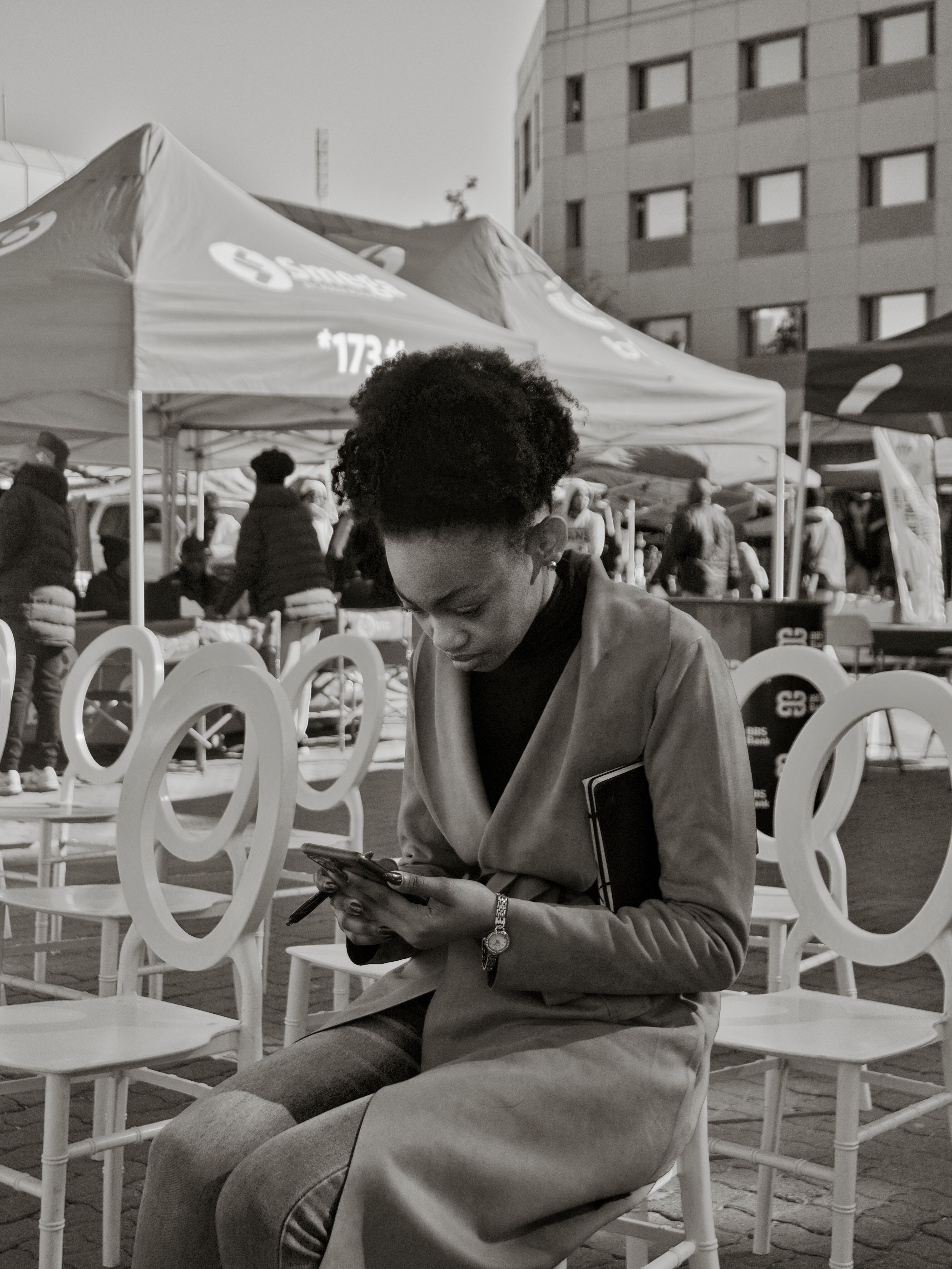 Even organiser sitting down, looking worriedly into her mobile phone.